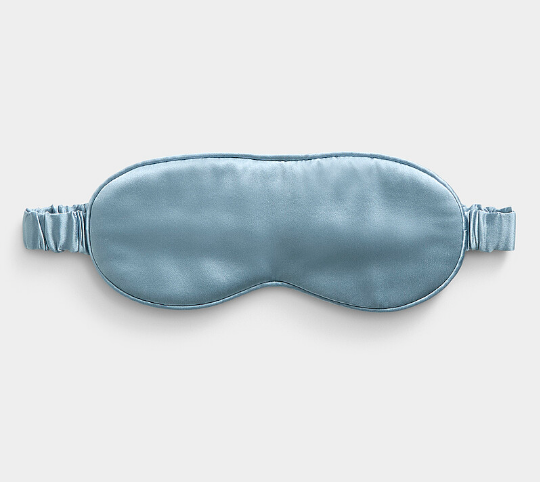 Blue satin sleep mask on a light gray background