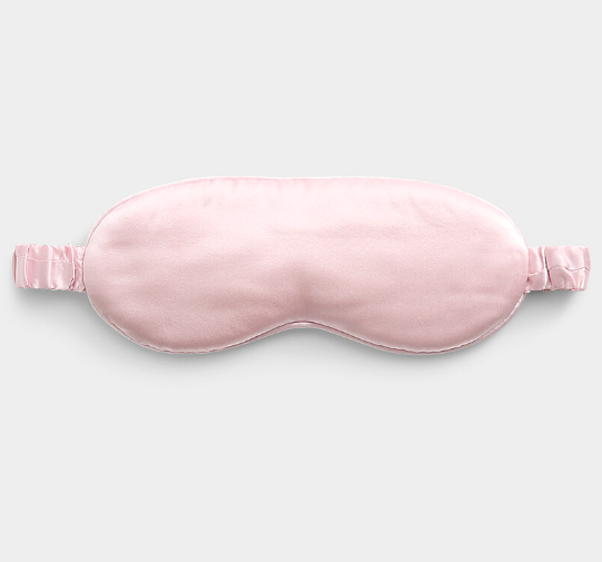 Pink satin eye mask on a light gray background