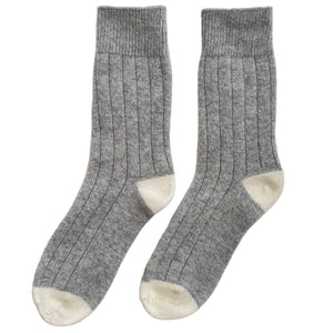 Pair of gray socks with white toes and cuffs on a light gray background