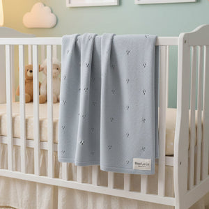 Folded gray baby blanket with 'Bleu La La Organics' label on a white background