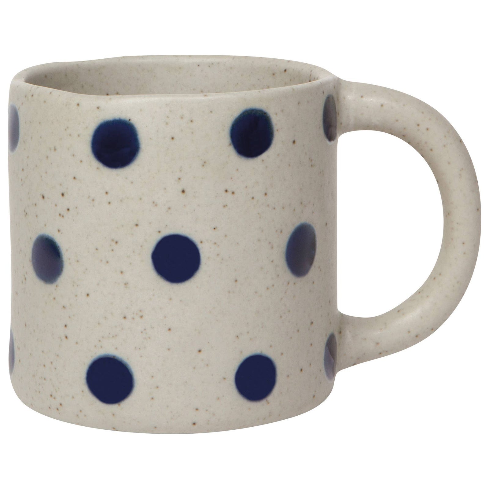 Person pouring milk from a polka dot ceramic pitcher into a matching mug on a light surface.