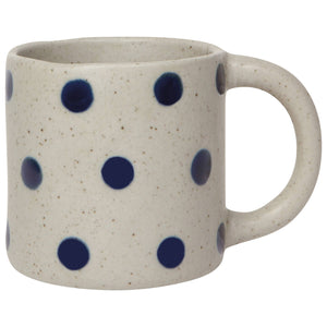 Ceramic mug with blue polka dots on a white background