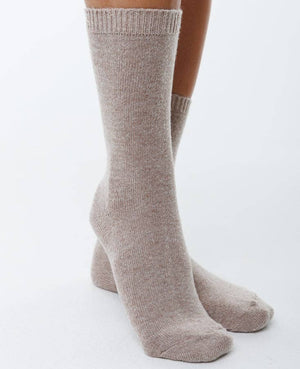 Beige socks worn by a person on a white background