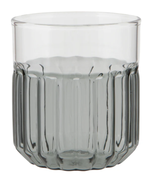 Set of smoked glass tumblers on a wooden surface with a bottle of amber liquid.