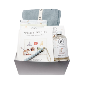 Baby gift set with book, blanket, and bottle in a box on a white background