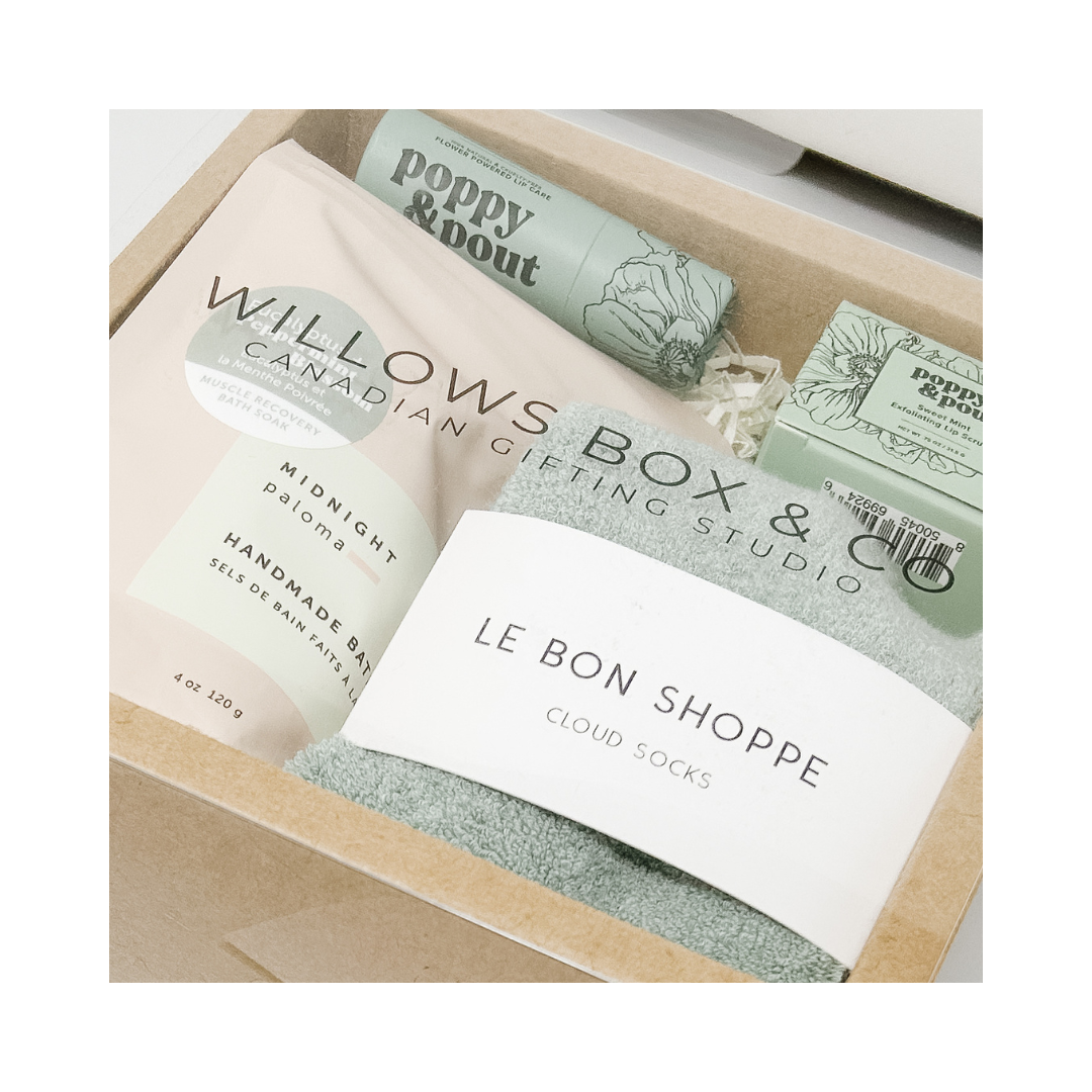 Box of bath products from Poppy & Pout, Midnight Paloma Bath, Cloud Socks in a gift box.