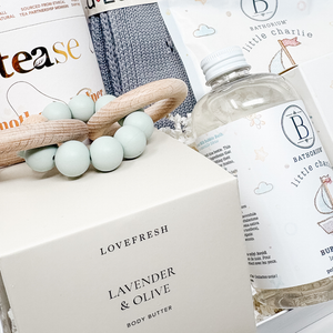 Bath products including a bottle labeled 'Bathorium' and a box of 'Lovefresh Lavender & Olive Body Butter' on a white surface.