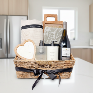 Gift basket with bath products and a bottle of wine on a white background
