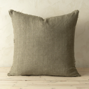 Textured brown pillow on a wooden surface with a neutral background
