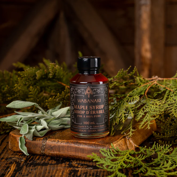 Bottle of Wabanaki Maple Syrup on a wooden board with greenery