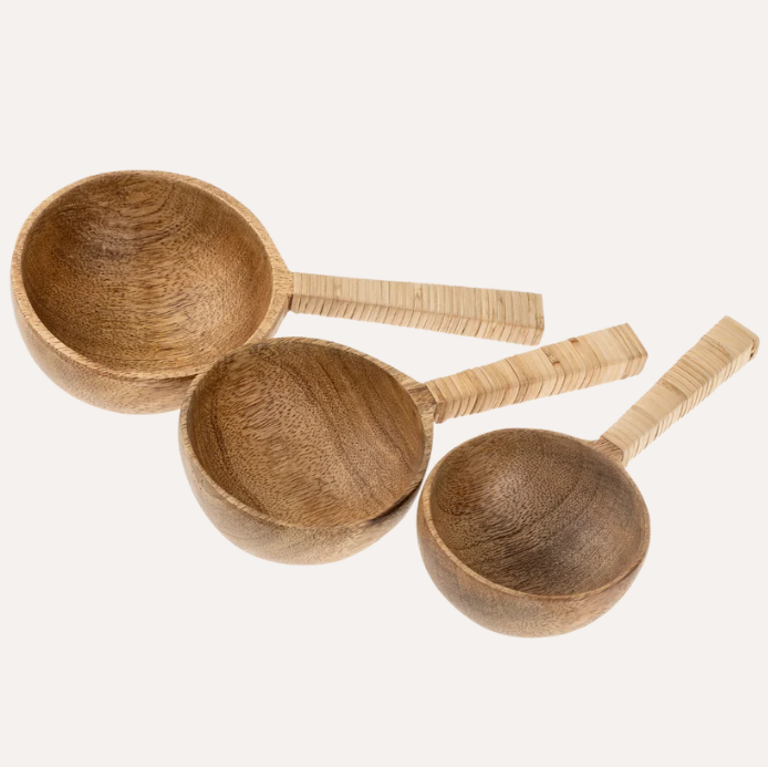 Three nested wooden measuring cups with long handles, shown on a plain off-white background.