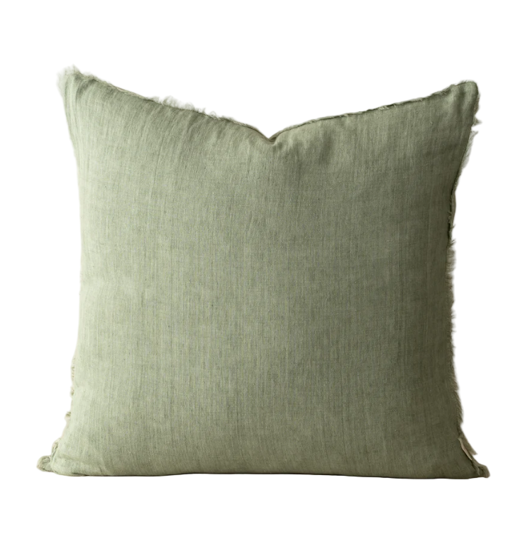 Green pillow with frayed edges on a white background