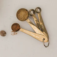 Set of brass measuring cups and spoons on a light surface