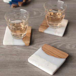 Coasters with glasses of liquid on a wooden surface