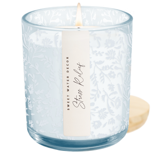 Candle in a textured glass jar with a label on a white background