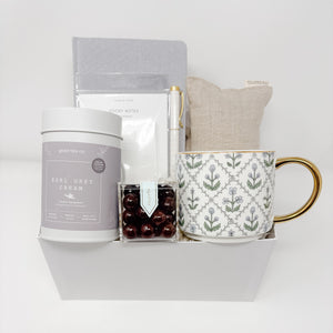 Gift set with tea, mug, and other items on a white background
