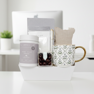 Gift basket with tea, mug, and other items on a white background