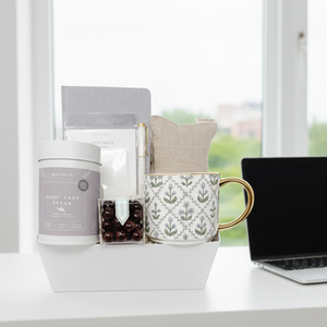 Gift basket with tea, mug, and other items on a white background