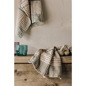 Plaid blanket draped over a wooden surface with a neutral background