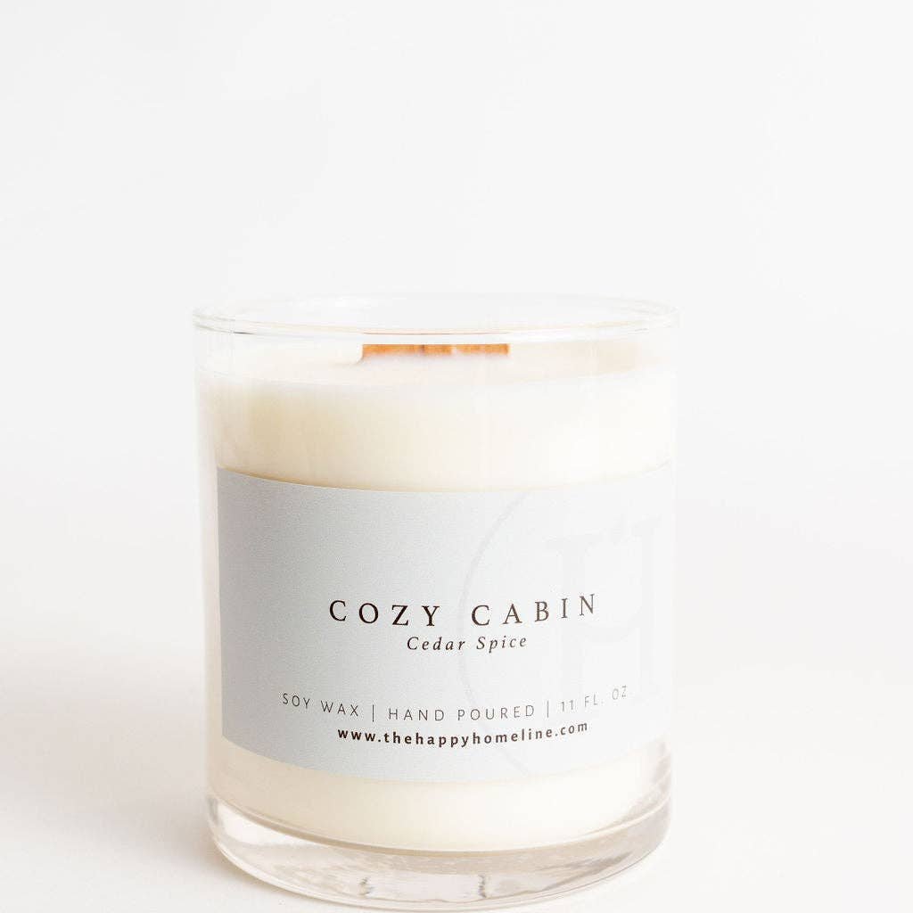 Candle with a label reading 'Cozy Cabin' on a white background