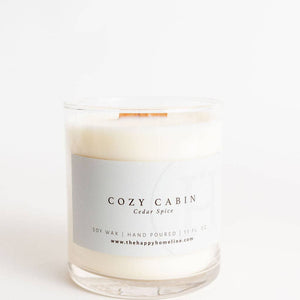 Candle with a label reading 'Cozy Cabin' on a white background