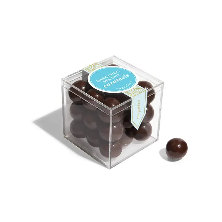 A pack of dark chocolate sea salt caramels by Sugarfina, presented in a clear packaging with the product visible through a transparent window.